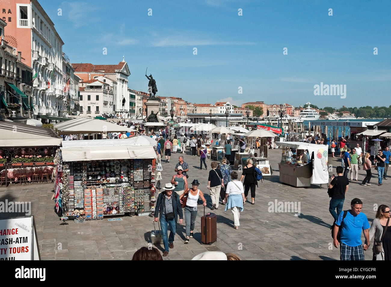 Turisti e bancarelle di souvenir sulla Riva degli Schiavoni, Venezia lungomare vicino a Piazza San Marco Foto Stock