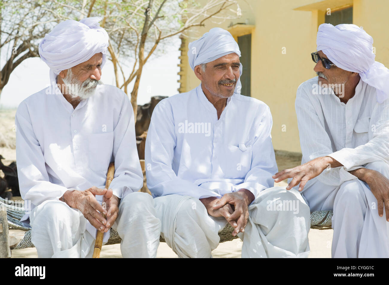 Tre gli agricoltori seduti insieme e discutere Foto Stock