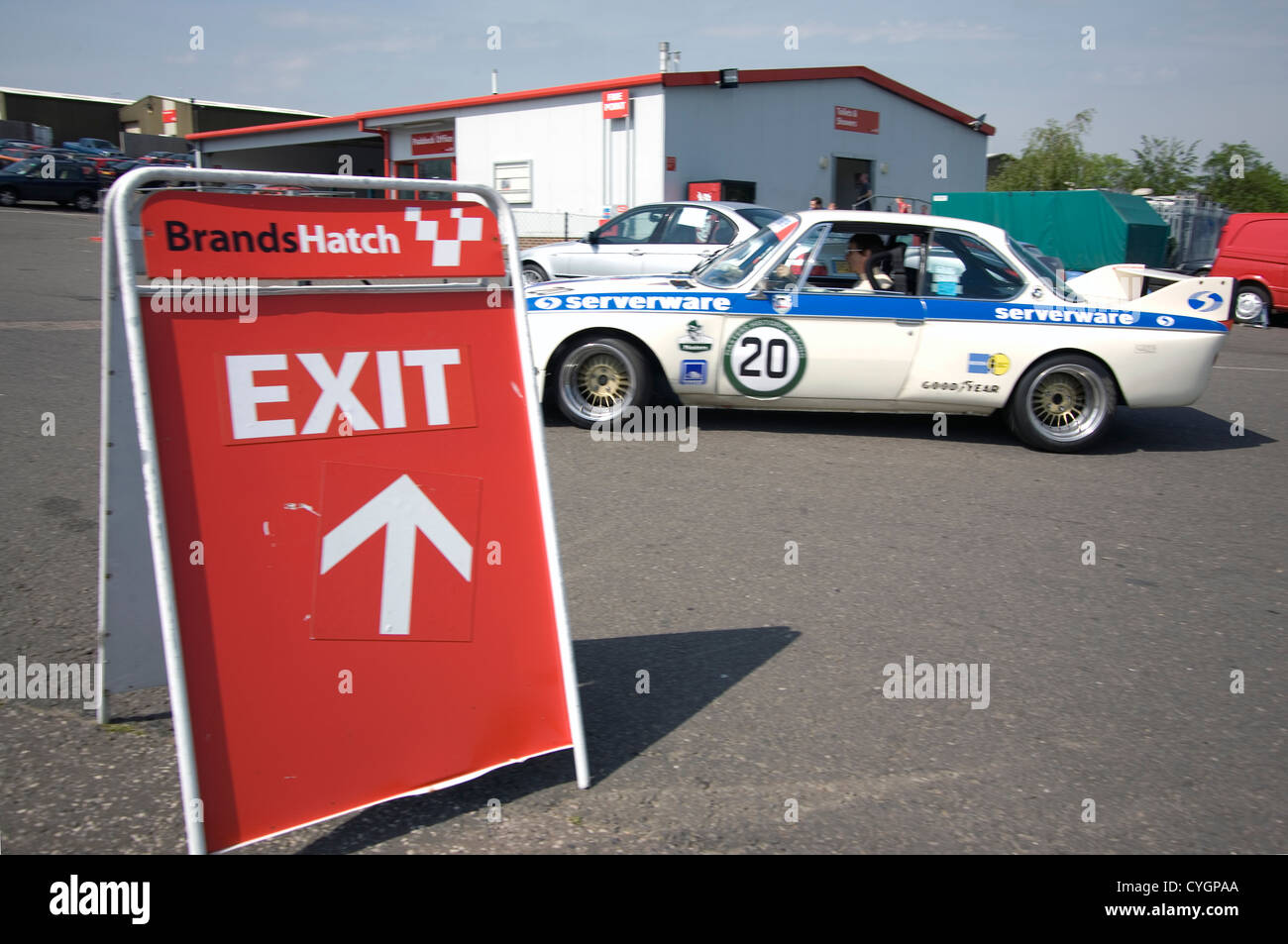 Una vettura da corsa guidando attraverso un segnale di uscita in corrispondenza di un circuito di gara. Foto Stock