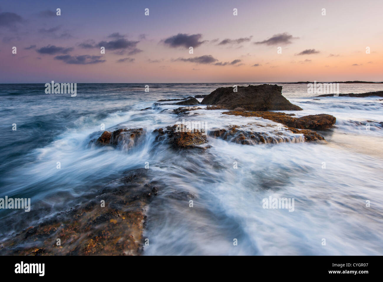 Il movimento ondoso su rock Beach in California Foto Stock