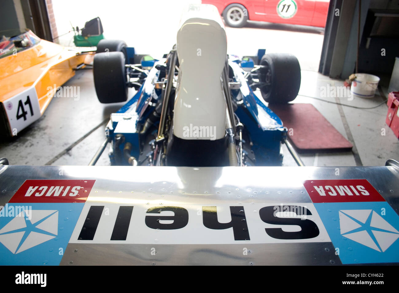 Una shell classica sponsorizzato auto di Formula Uno seduto in un garage prima di una gara. Foto Stock