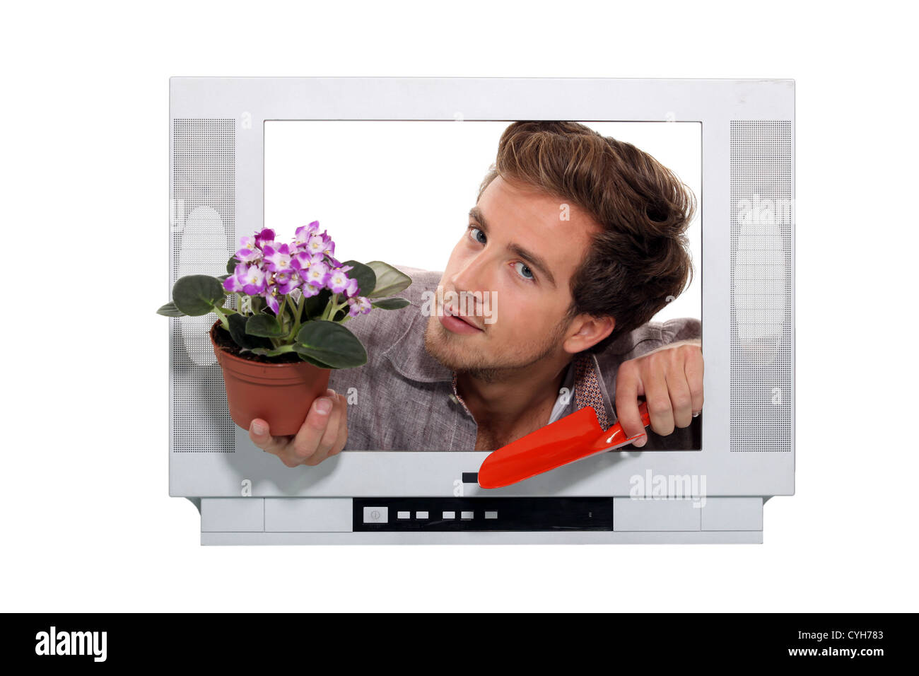 Uomo vaso di foratura e una cazzuola guardando attraverso un frame televisivo Foto Stock