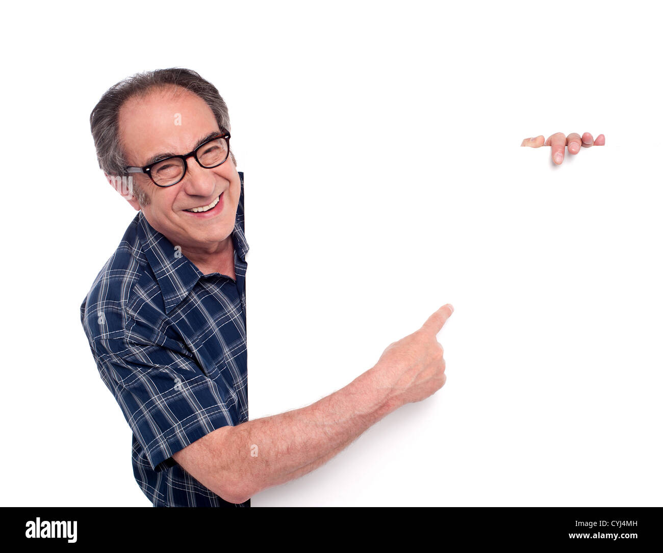 L'uomo puntando al bianco poster in bianco e sorridente. Indossare occhiali Foto Stock