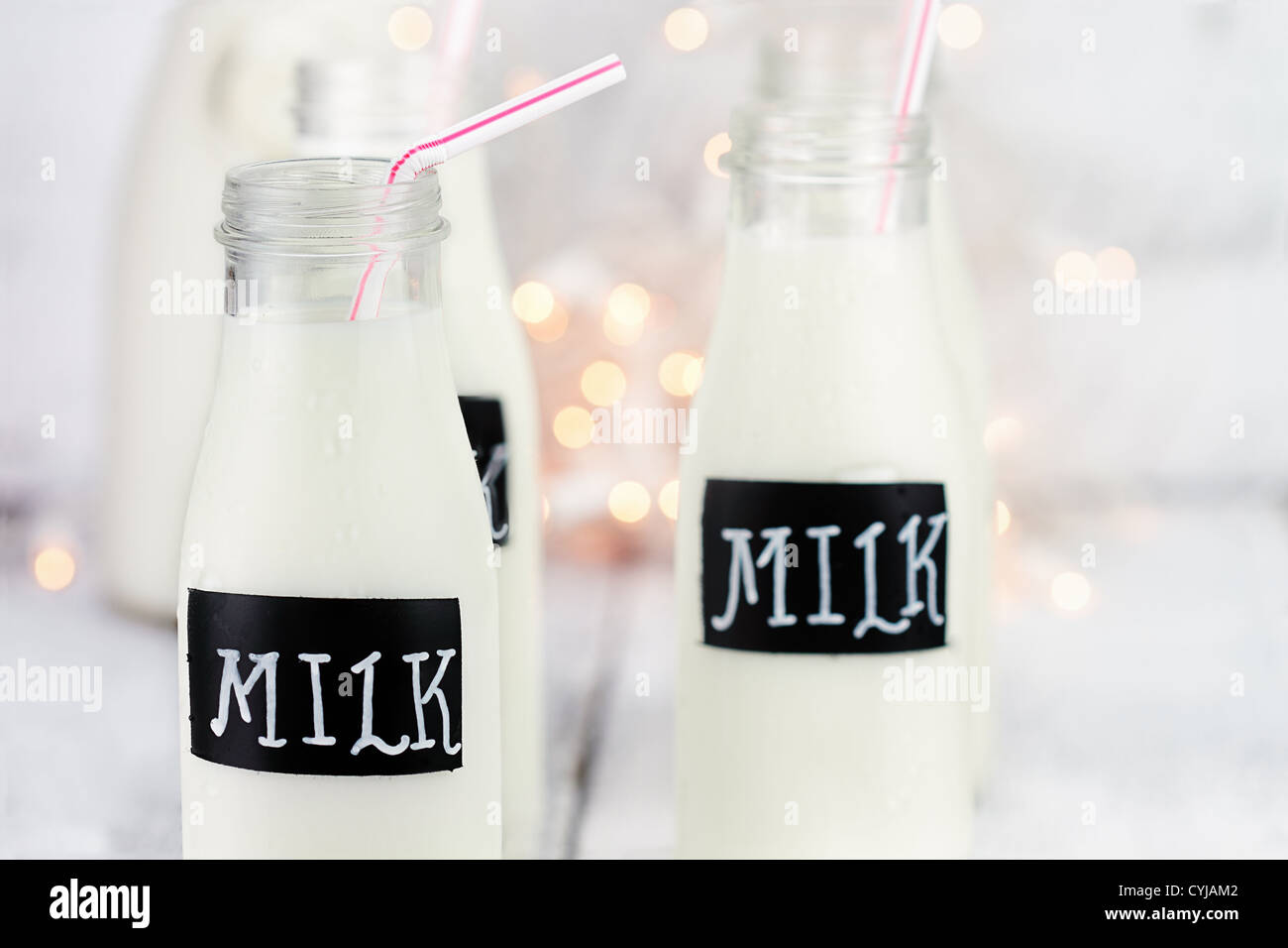 Bottiglie di vetro di latte con cannucce e antichi bottiglia di latte in background. Profondità di campo. Foto Stock