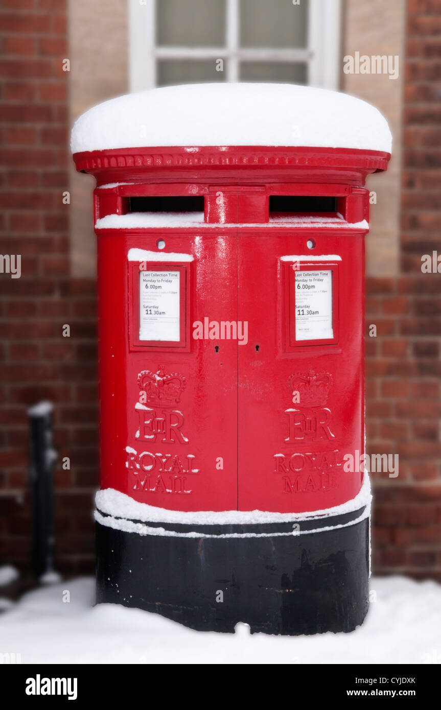 Un rosso inglese pilastro casella in inverno la neve. Foto Stock