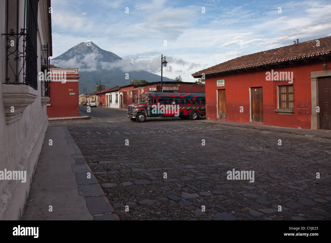 Coloratissimo pollo contrasto autobus la splendida architettura antica e le strade lastricate di Antigua, Guatemala. Foto Stock