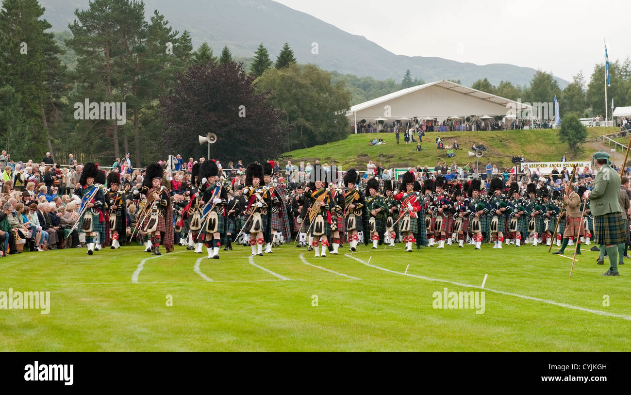 Ammassato Pipe Band giocando a Braemar Royal Highland Gathering. Braemar, Aberdeenshire, Scozia Foto Stock