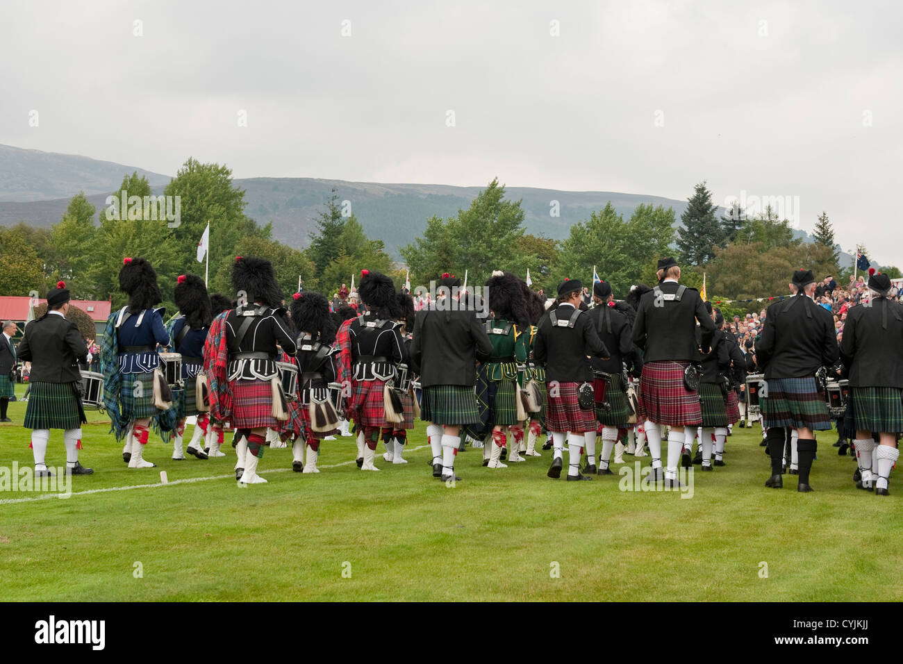 Ammassato Pipe Band giocando a Braemar Royal Highland Gathering. Braemar, Aberdeenshire, Scozia Foto Stock
