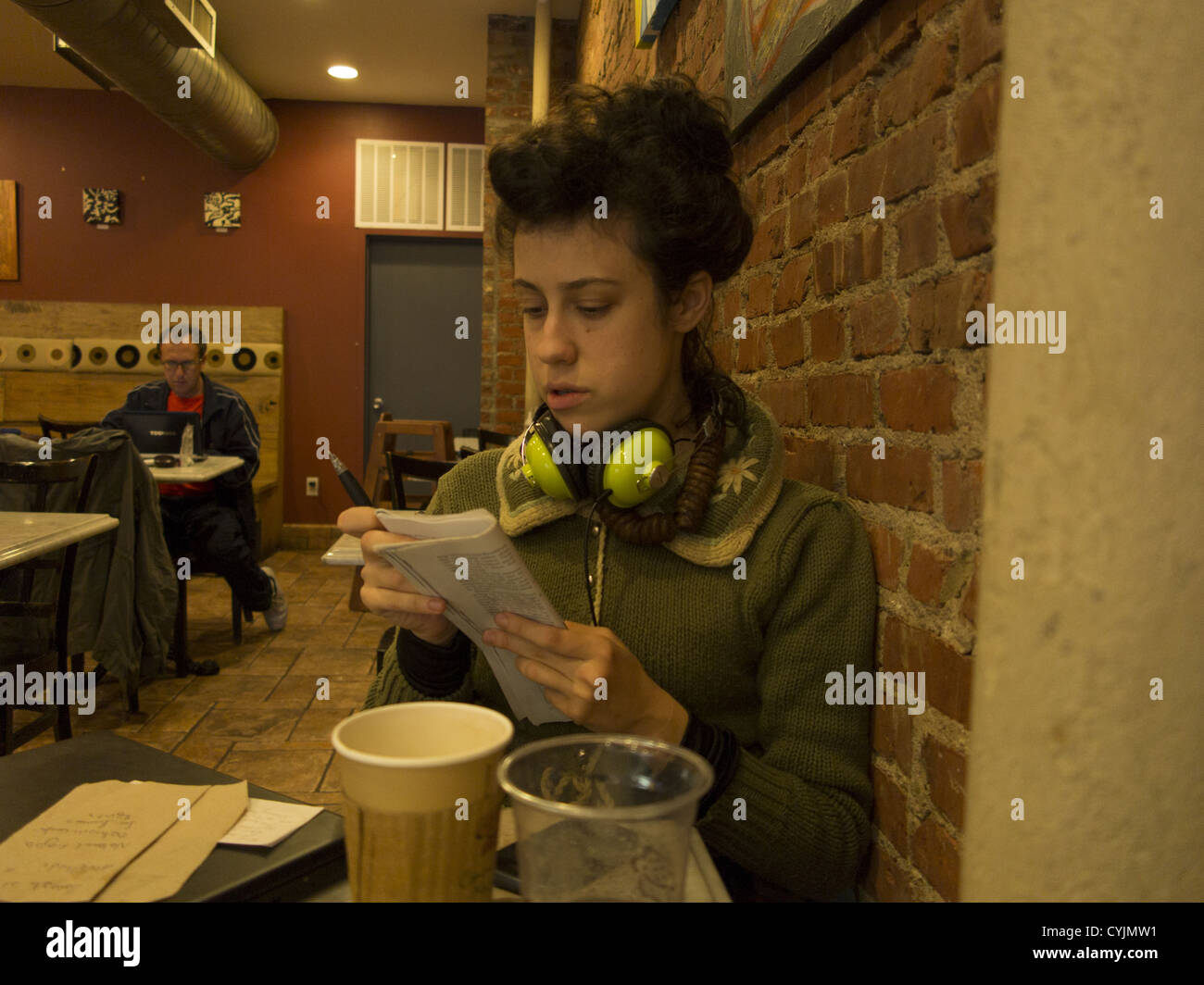 Giovane donna letture e studi in un caffè di Brooklyn, New York. Foto Stock