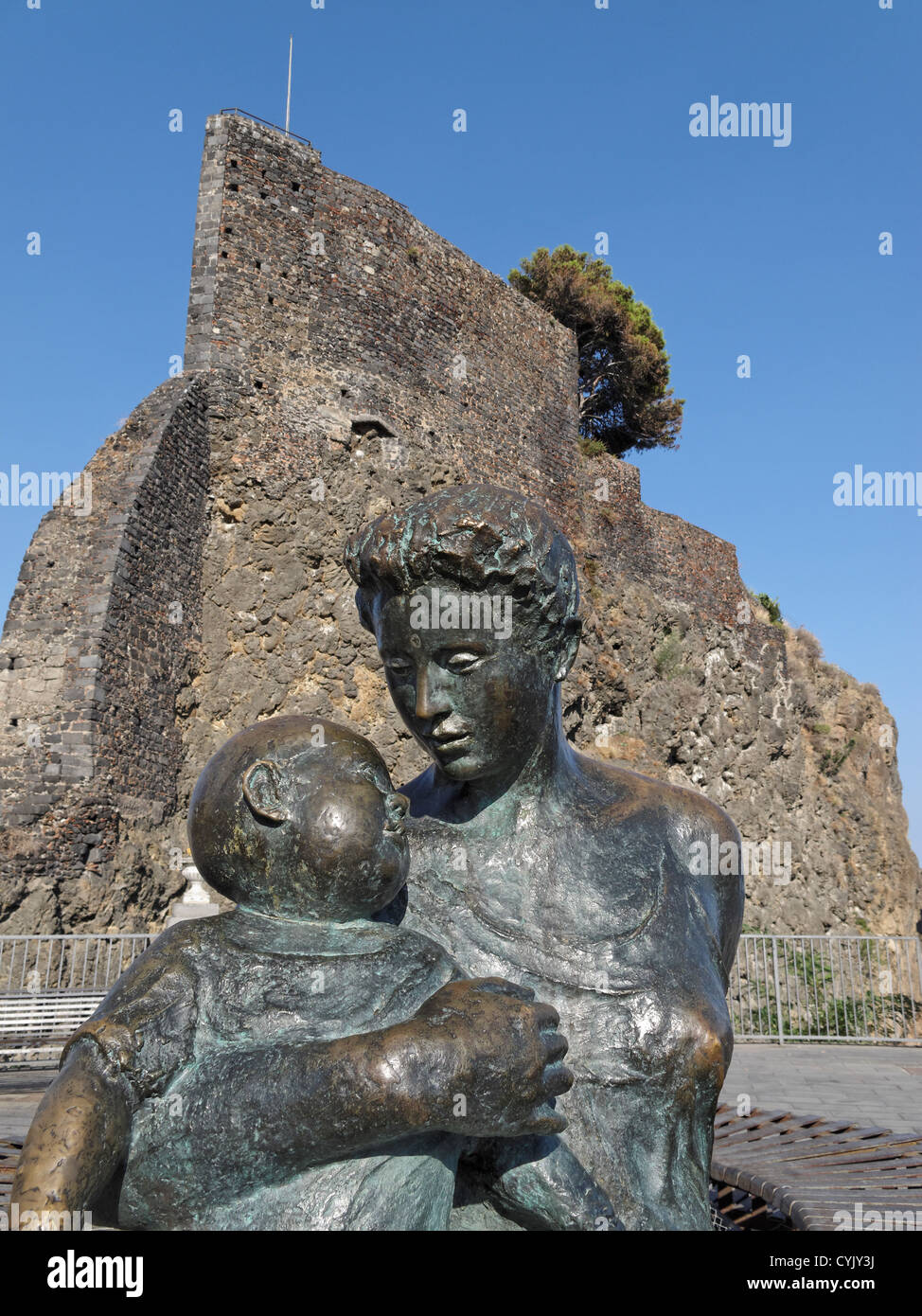 Una statua di una madre e un bambino di fronte al castello normanno a Aci Castello, Sicilia, Italia. Foto Stock