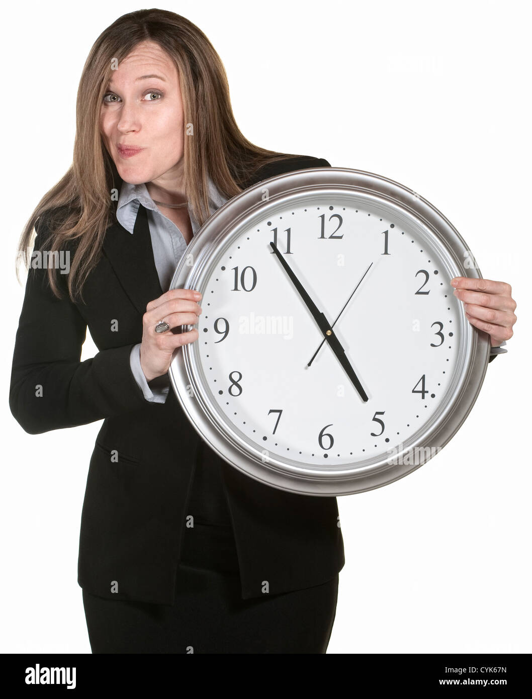 Donna fare volti e tenendo un grande orologio analogico Foto Stock