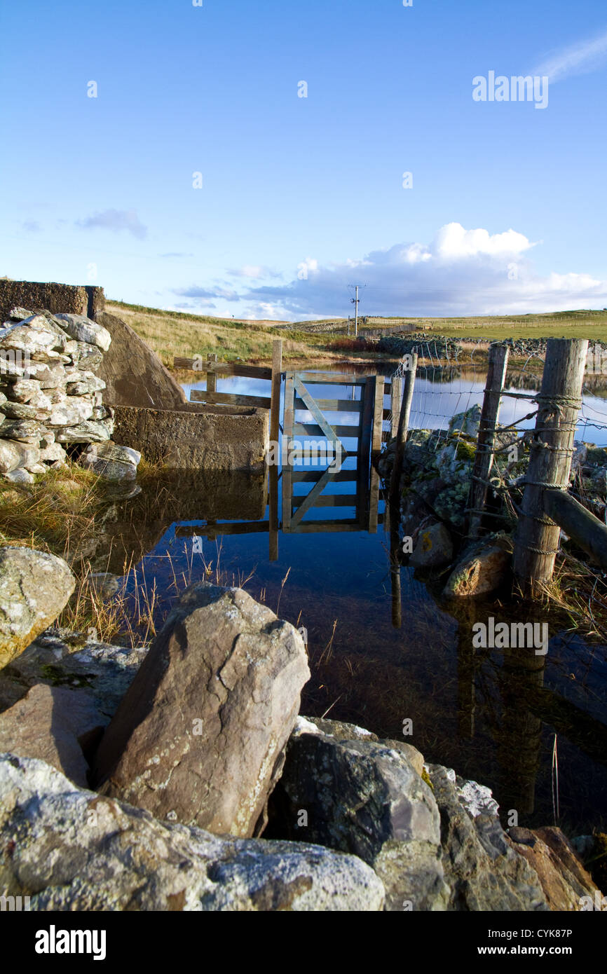 Una passeggiata costiera il sentiero conduce attraverso una semi-sommersa, gate impraticabile a causa della marea Foto Stock