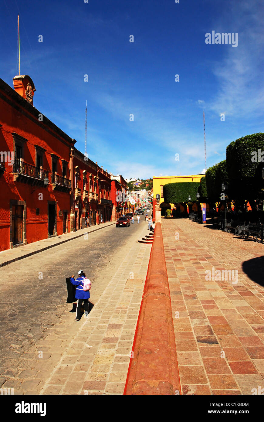 Messico, San Miguel De Allende, street con i suoi colorati tipiche case messicane, donna borsa per il trasporto Foto Stock