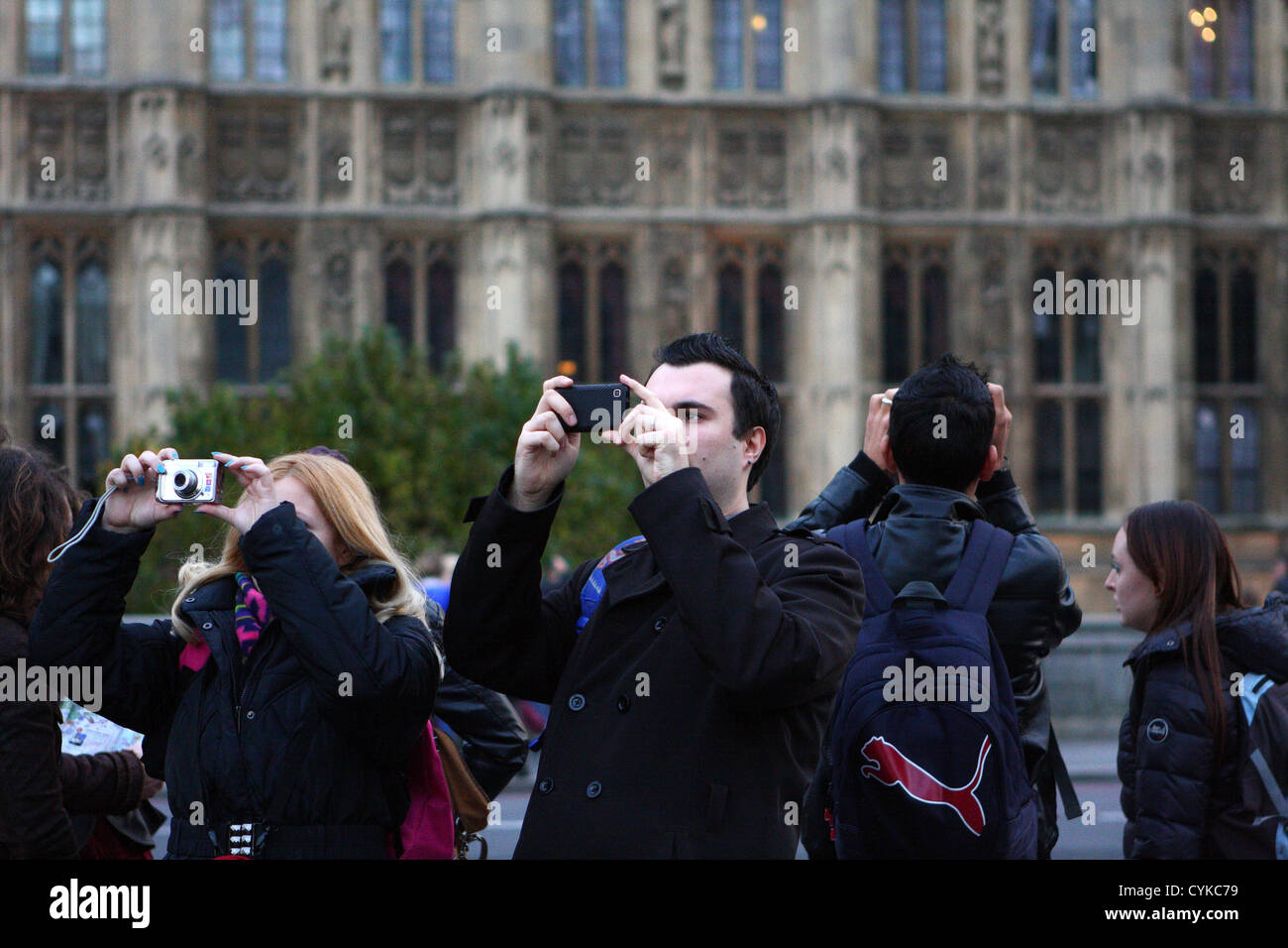 Le persone scattano fotografie vicino al Palazzo del Parlamento a Londra Foto Stock