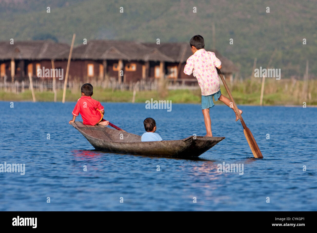 Myanmar Birmania. Giovane ragazzo birmano canottaggio canoa con una gamba, in uno stile comune per il Lago Inle, Stato di Shan. Foto Stock