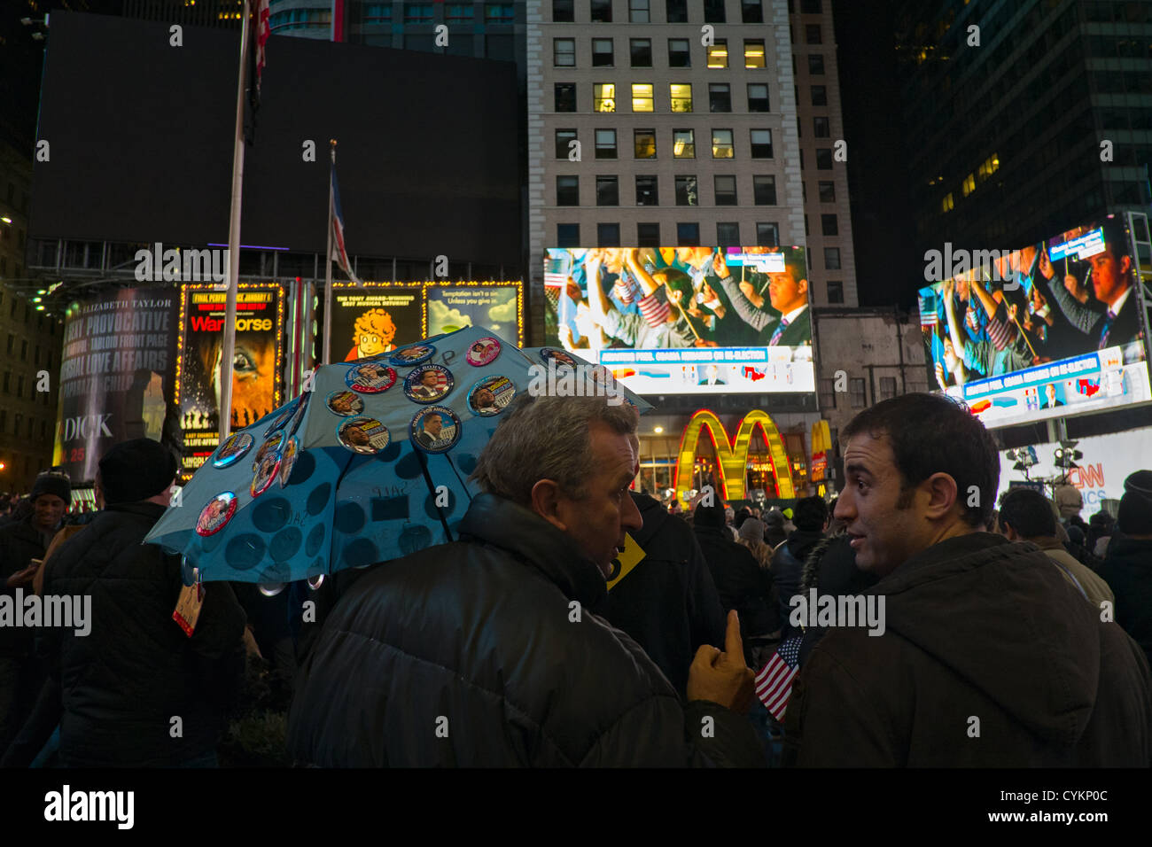 November 7, 2012, New York, NY, USA. L'uomo vendita di Obama e Romney buttonss campagna come la folla in Times Square festeggia il Presidente Barack Obama la rielezione di vittoria nel 2012 Stati Uniti elezioni presidenziali. Foto Stock