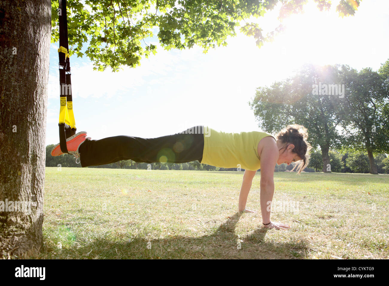 Donna facendo ups push nel campo Foto Stock