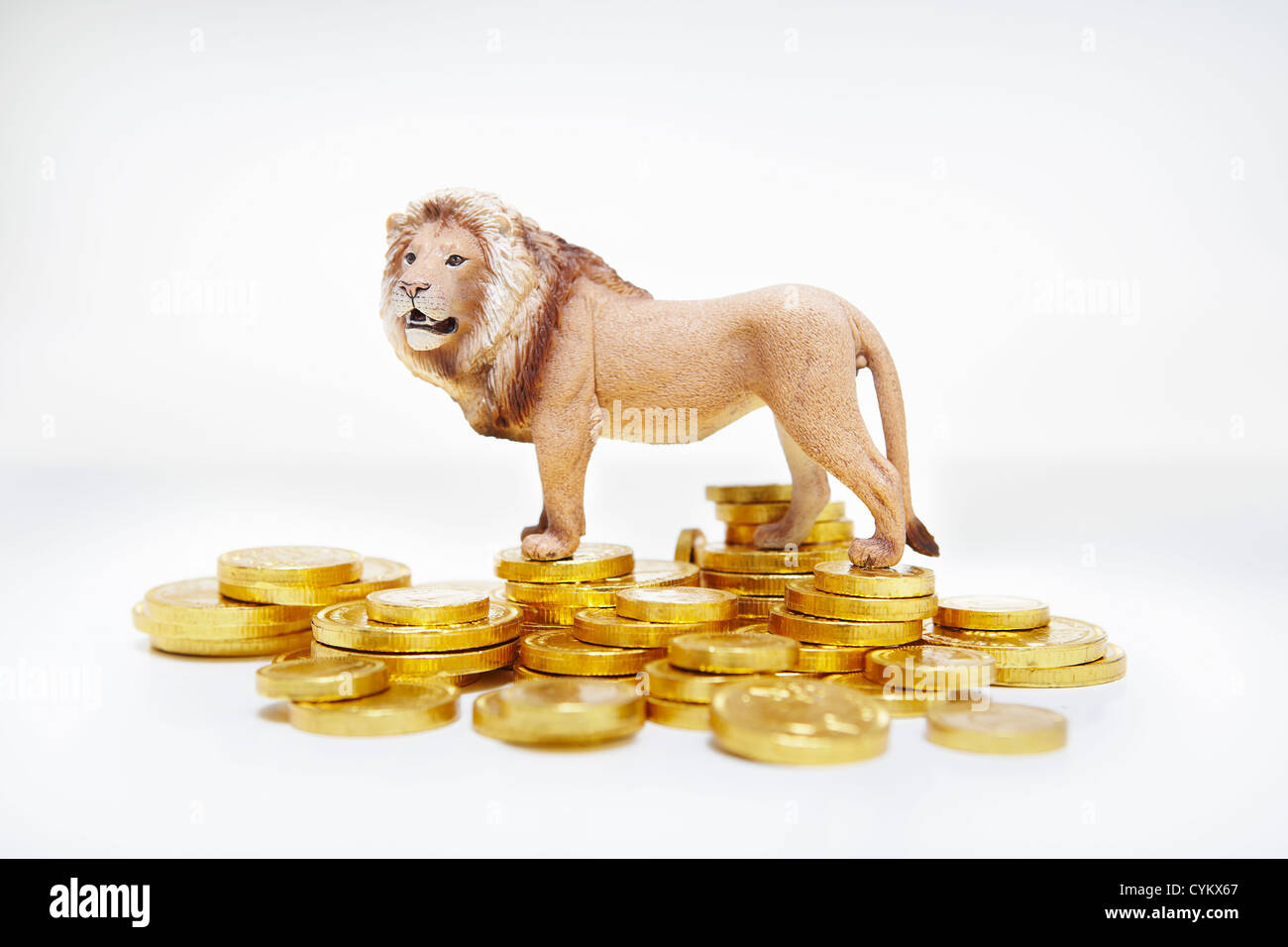 Toy lion su pile di monete d'oro Foto Stock