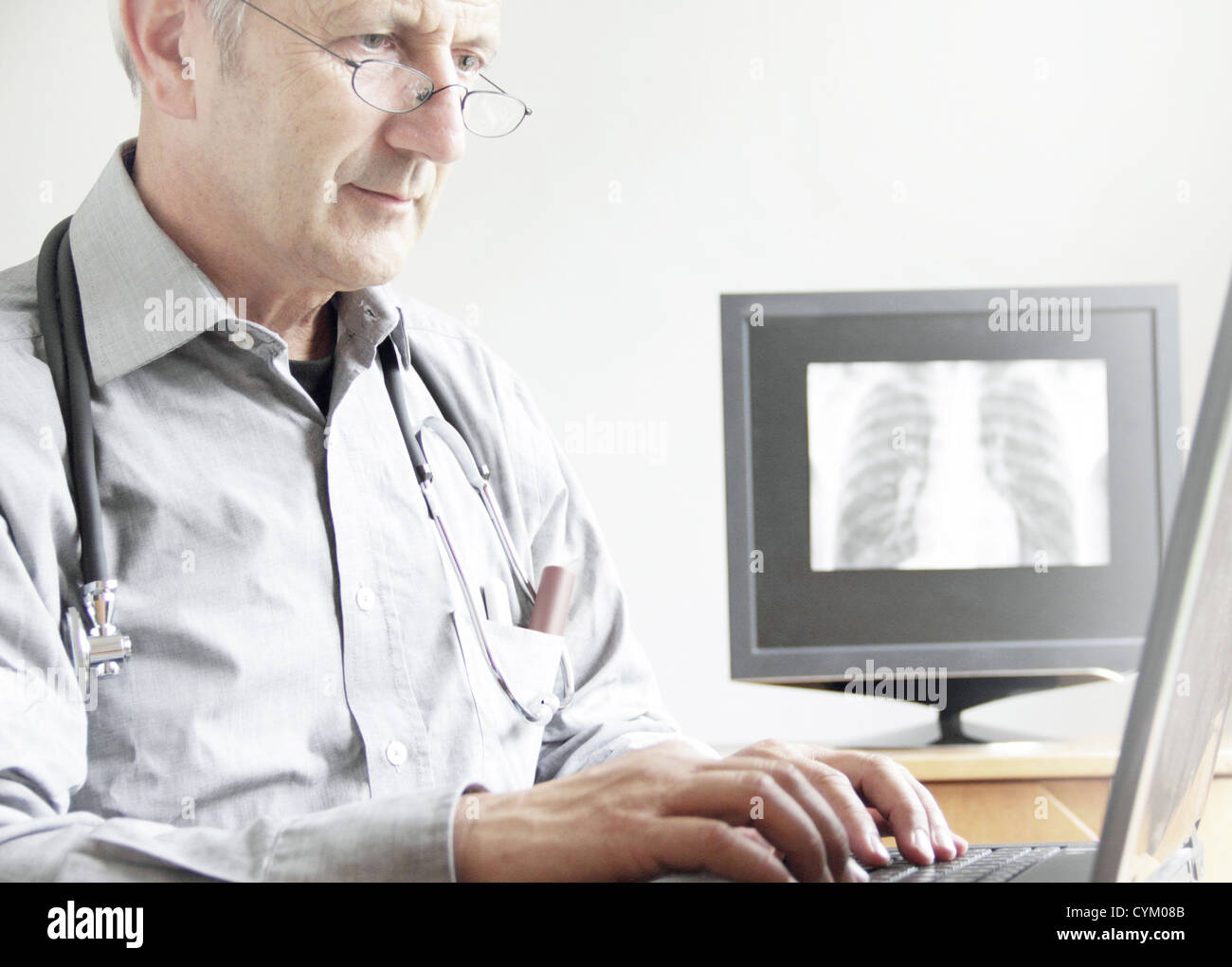 Medico utilizzando computer portatile in ufficio Foto Stock