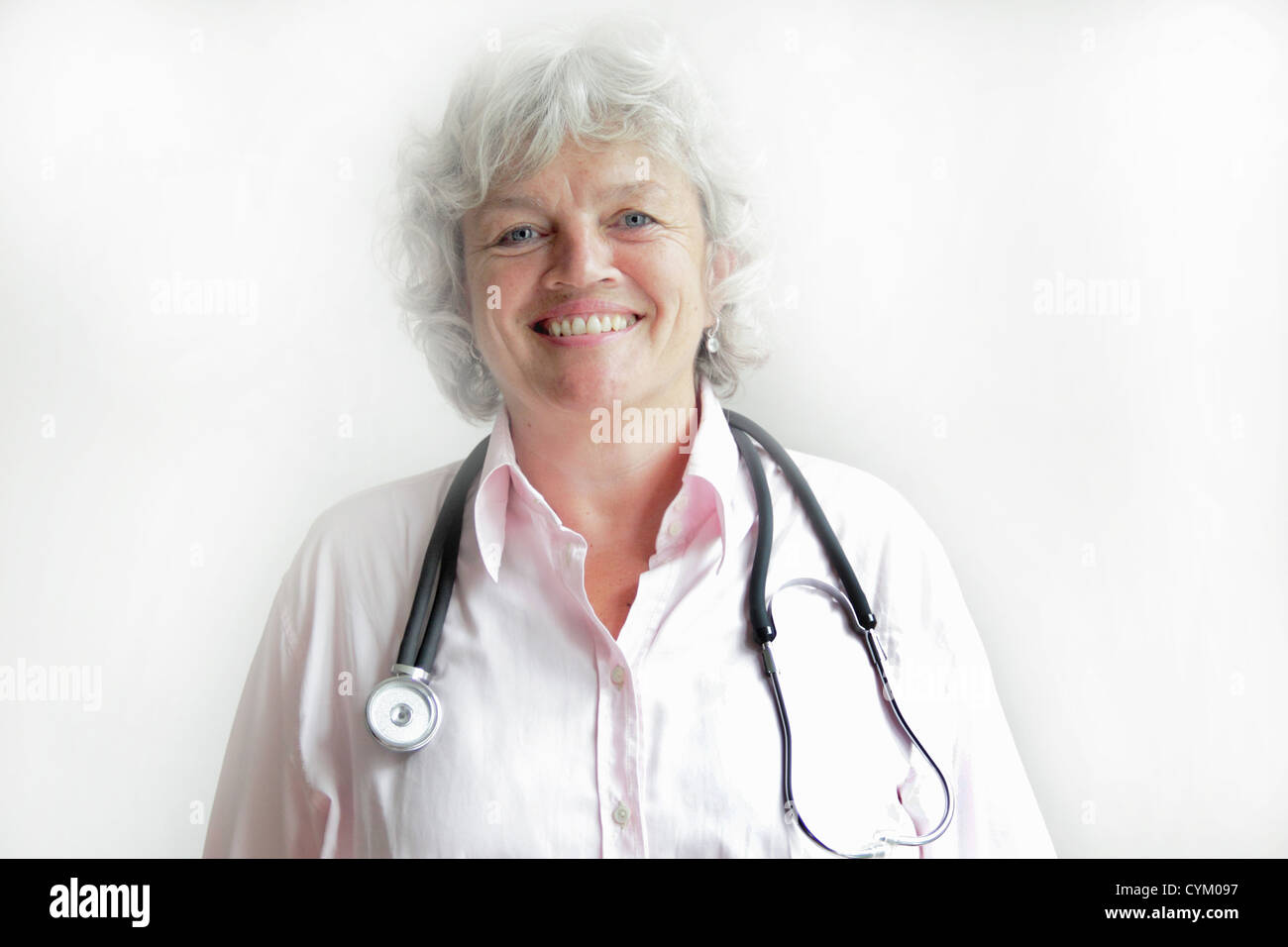 Medico sorridente indossando uno stetoscopio Foto Stock