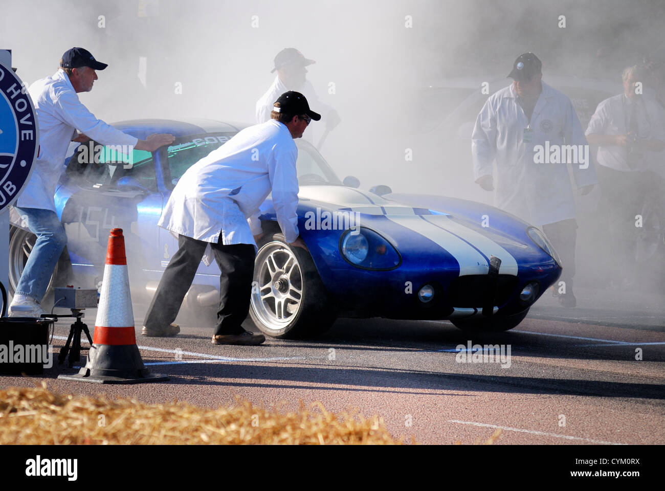 Il fumo del pneumatico a corsa in auto sulla linea di partenza Foto Stock