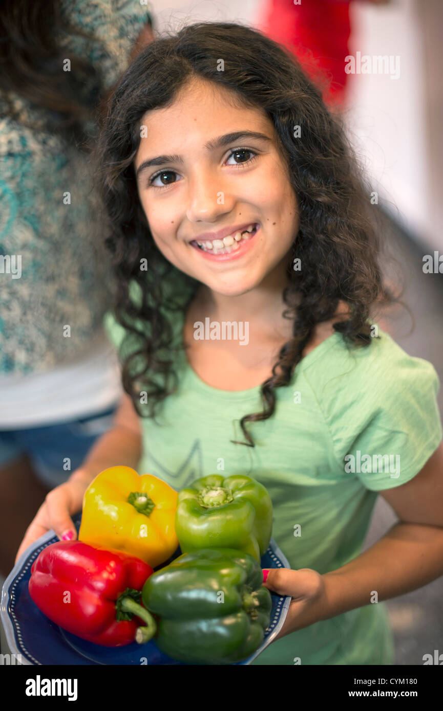 Sorridente ragazza con una ciotola di peperoni Foto Stock