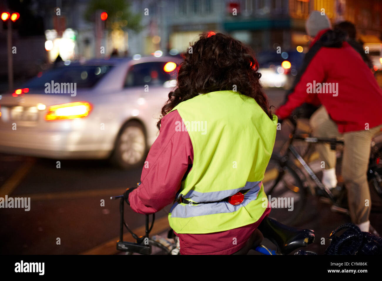 Donna che indossa alta vis vest escursioni in bicicletta di notte nel centro della città di Dublino Repubblica di Irlanda Foto Stock