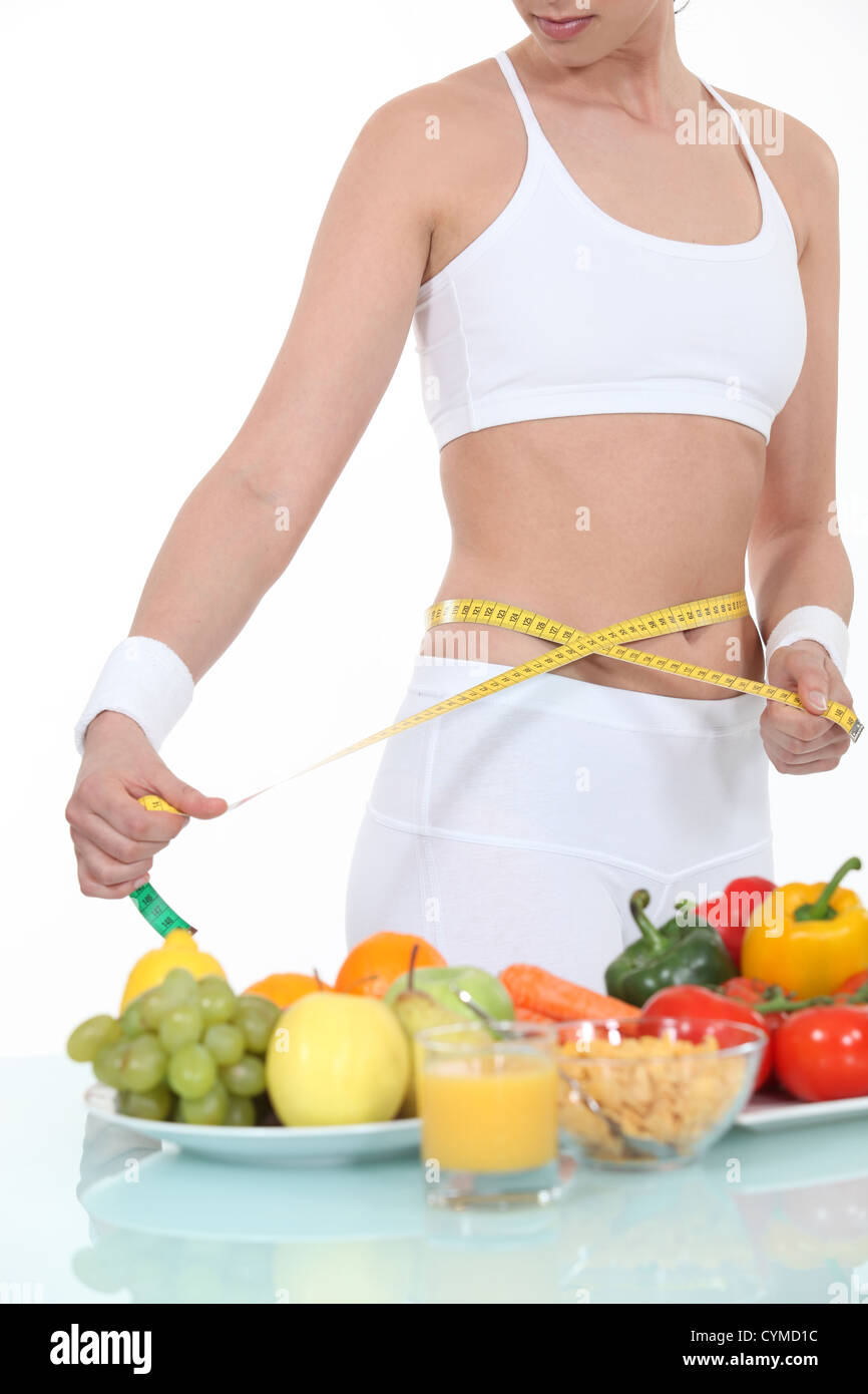 Donna misurando la sua vita Foto Stock