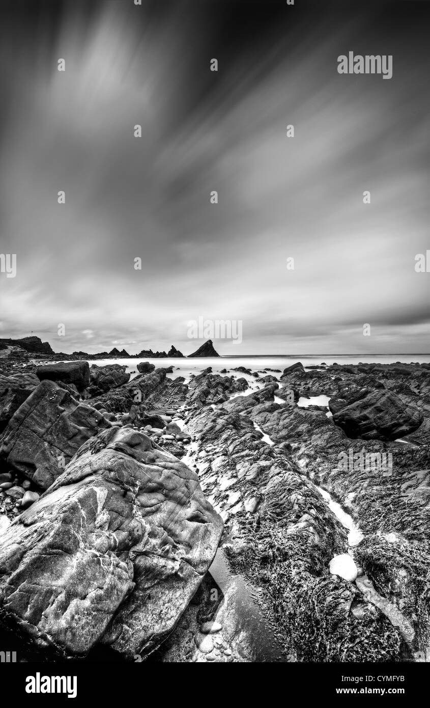 La marea su questa pittoresca ancora drammaticamente spiaggia robusto a Hartland Quay sulla North Devon Coast Foto Stock