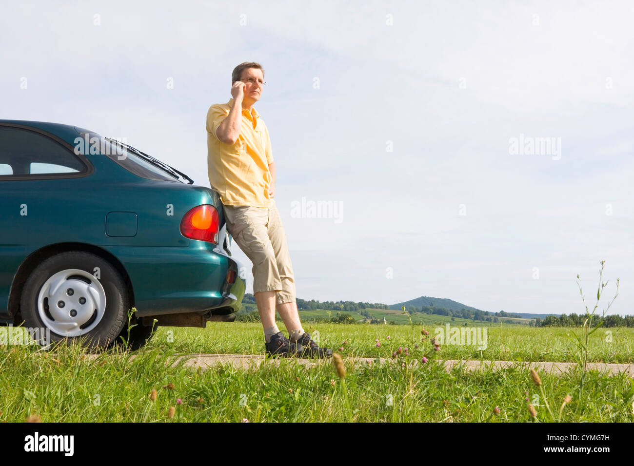 L'uomo parlando al cellulare accanto alla sua vettura che ha un guasto o di un vuoto del serbatoio del gas Foto Stock