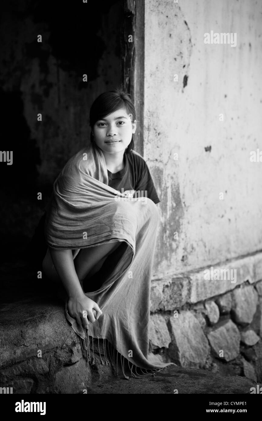 Una giovane ragazza indonesiana comporta per il suo ritratto di una porta, Lombok, Indonesia. Foto Stock