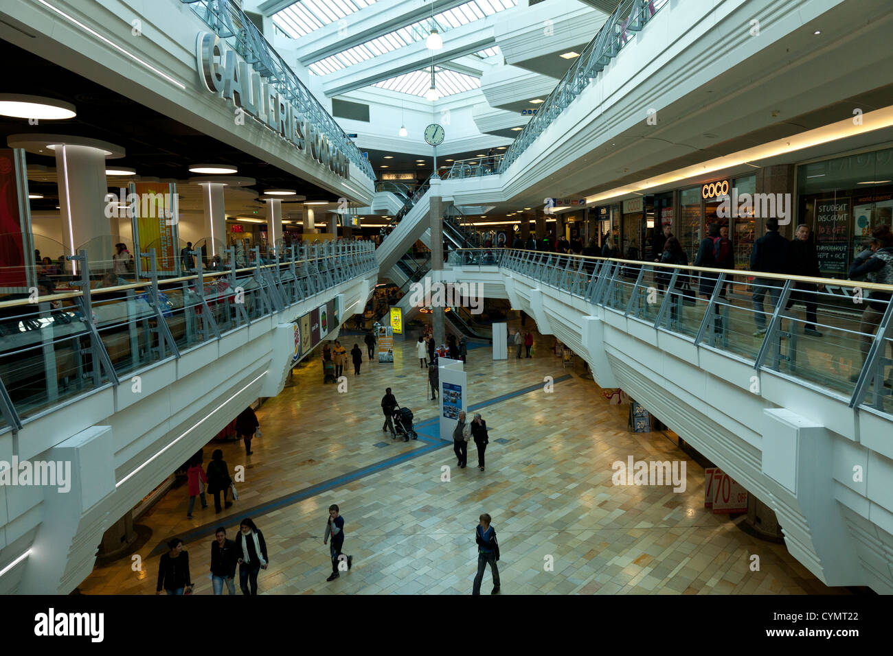Scale mobili e scale modi criss traversata nel moderno centro commerciale centro, le gallerie shopping centre a Bristol, Inghilterra, Regno Unito. Foto Stock