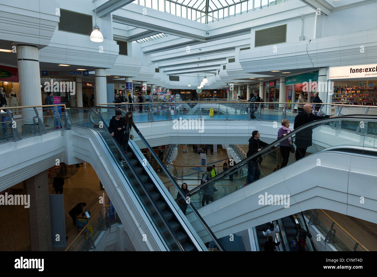 Scale mobili e scale modi criss traversata nel moderno centro commerciale centro, le gallerie shopping centre a Bristol, Inghilterra, Regno Unito. Foto Stock