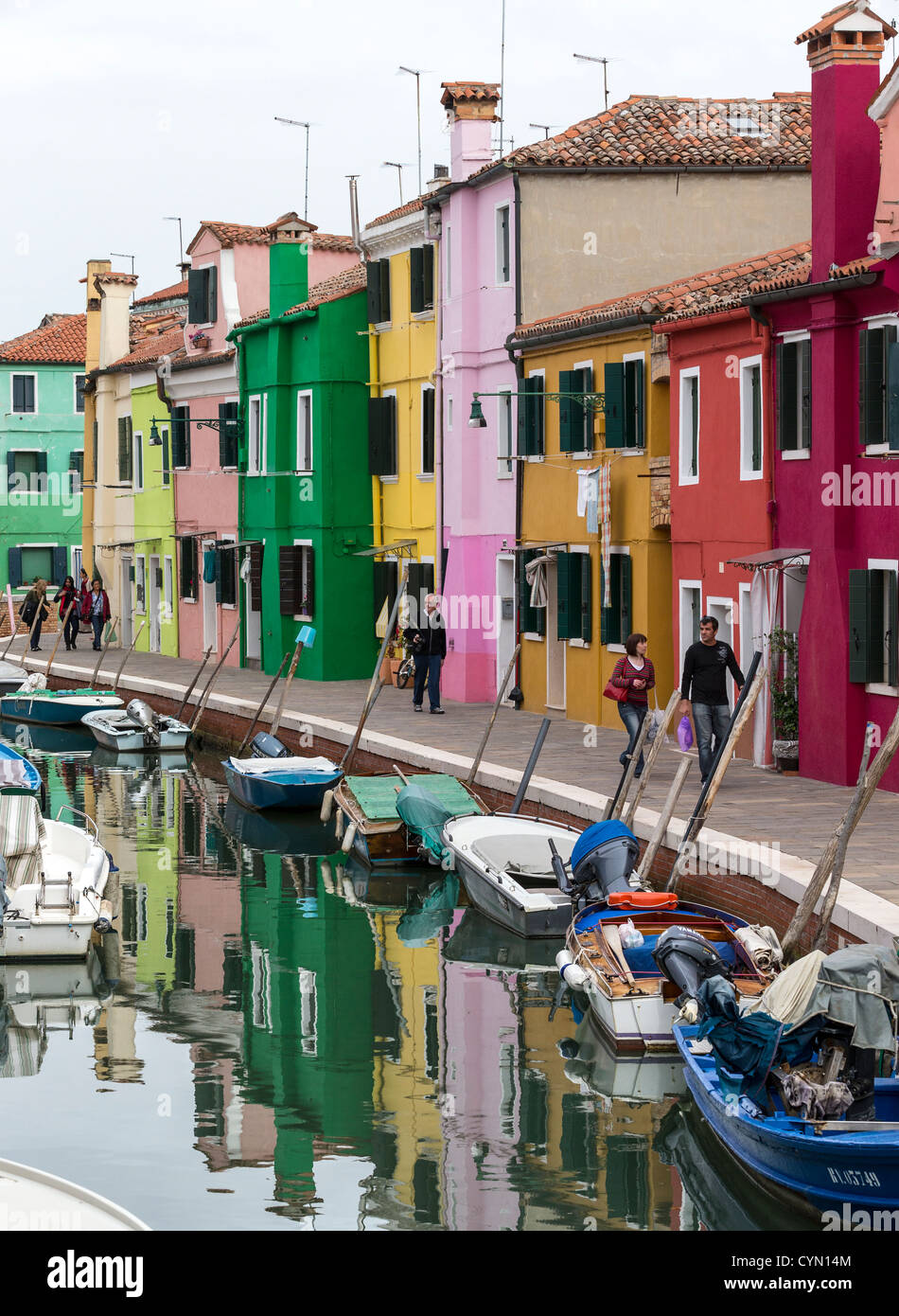 Case dai colori vivaci su una strada di Burano, Venezia, con le loro riflessioni nel canale o rio. Foto Stock