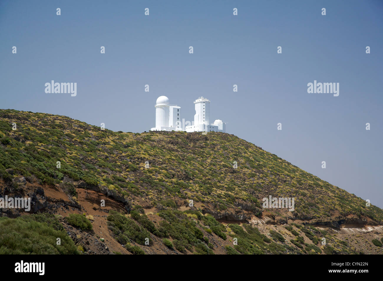 Astrofisica di edifici bianchi su una montagna verde Foto Stock