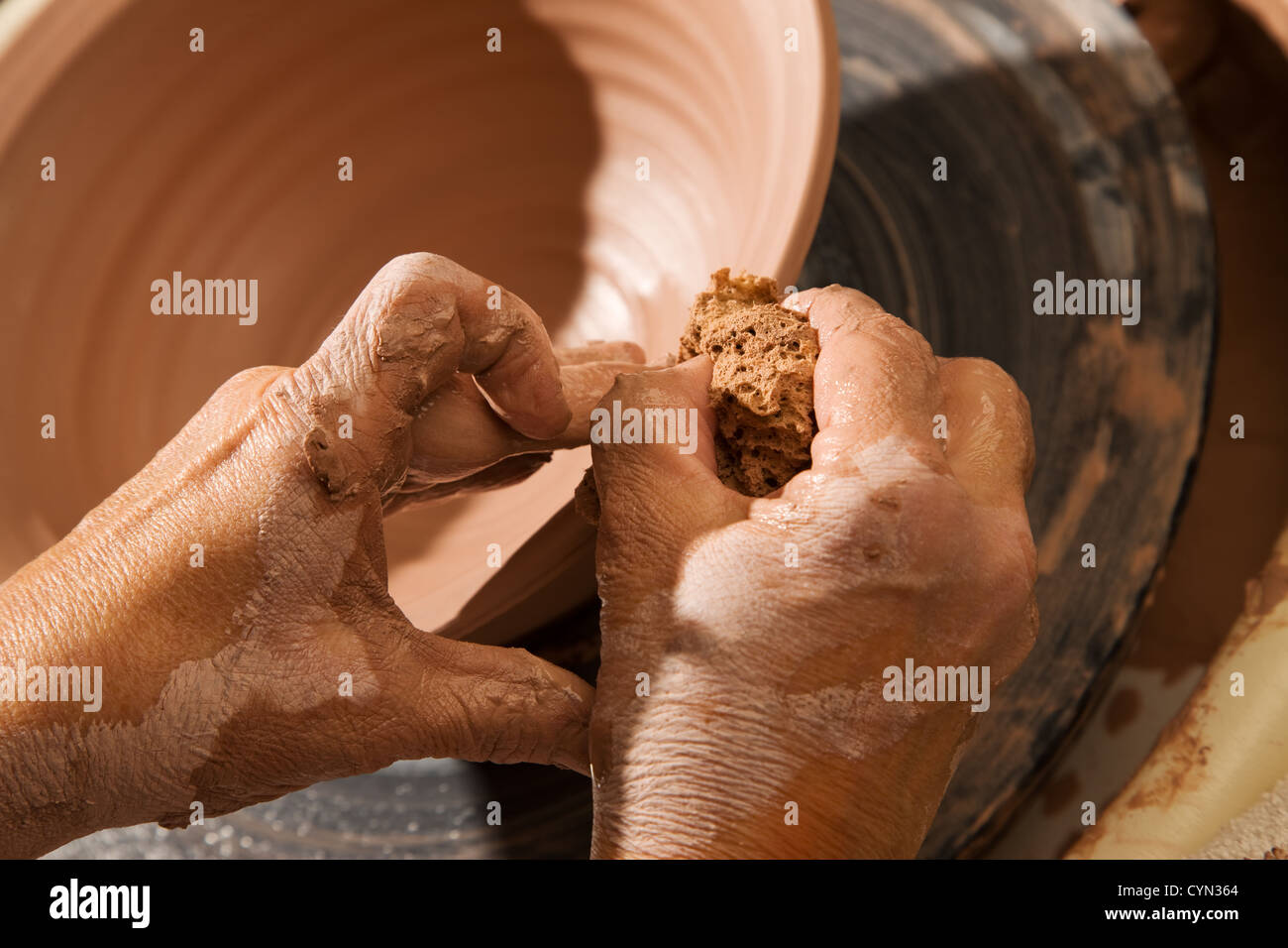 Mani formando pentola di creta sulla ruota in ceramica Foto Stock