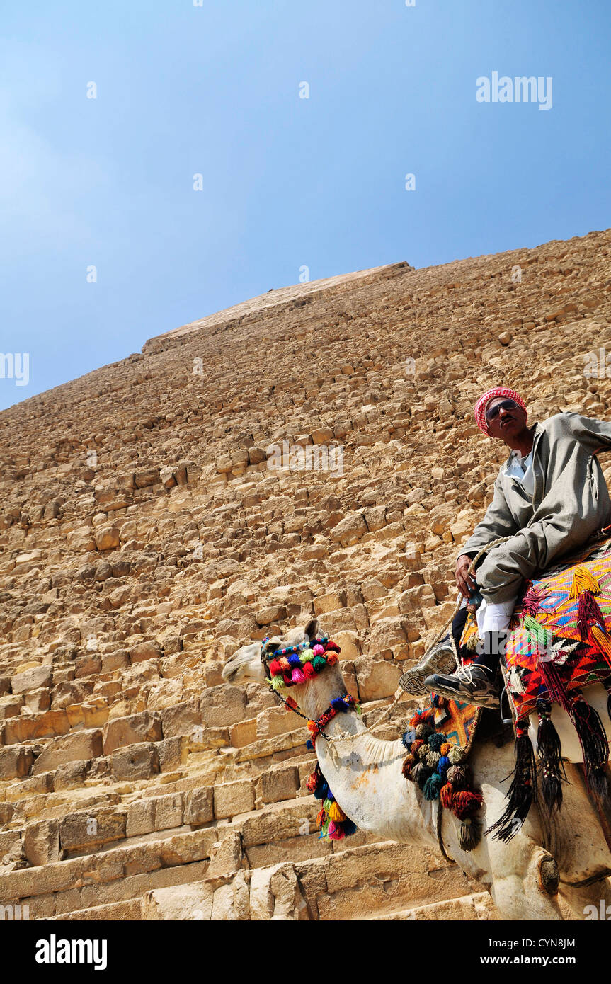 Un egiziano uomo seduto sul suo cammello dalla grande Piramide di Giza. Foto Stock
