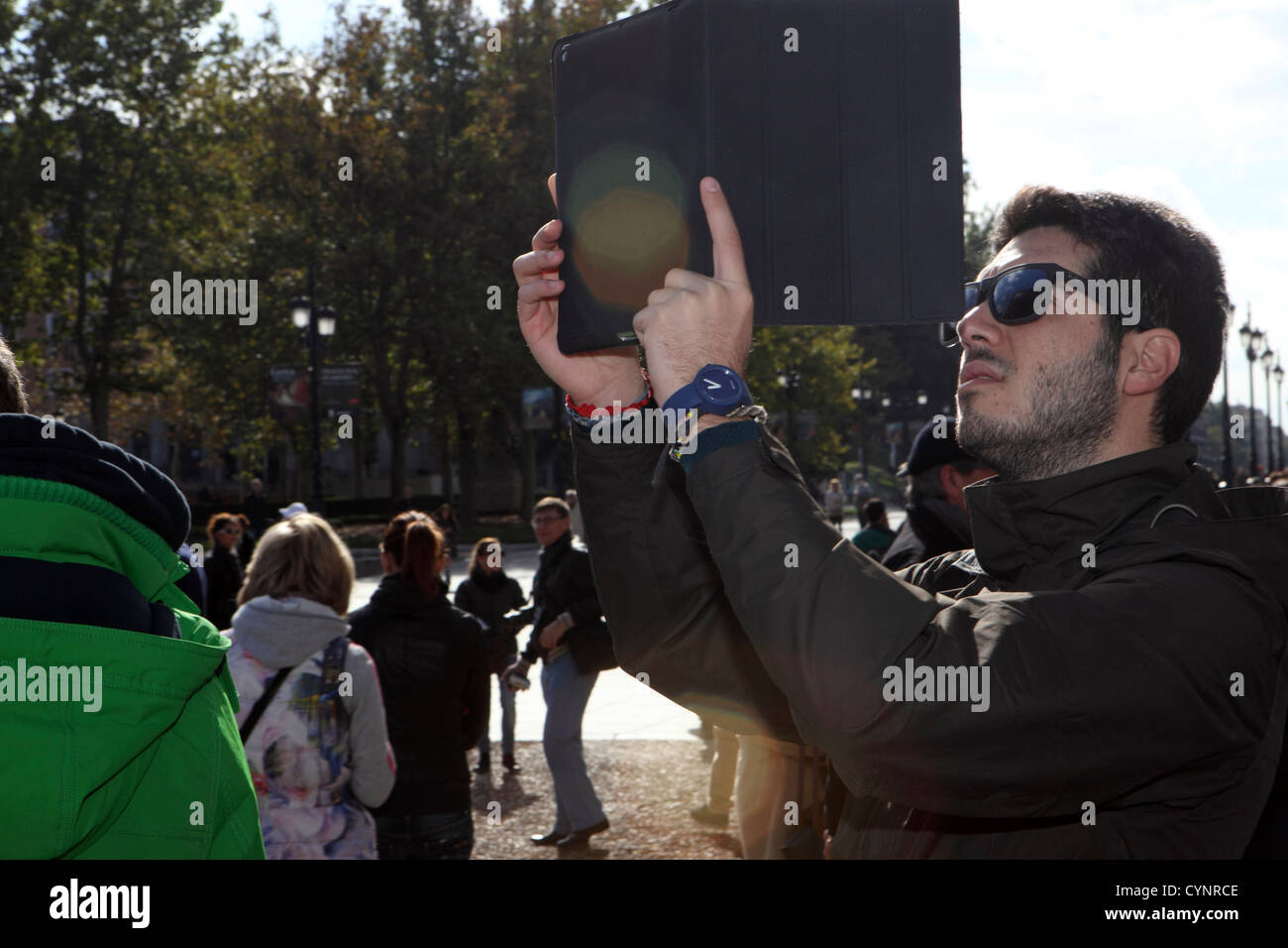 Tourist prende fotografia utilizzando iPad computer portatile elettronico mobile computer tablet dispositivo, Madrid, Spagna Foto Stock