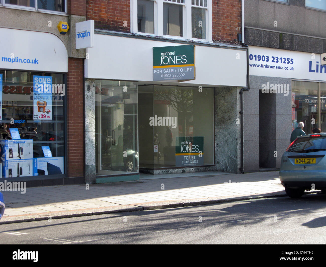 Vuoto non occupato store retail in Worthing West Sussex Regno Unito con una di lasciare in vendita la scheda Foto Stock