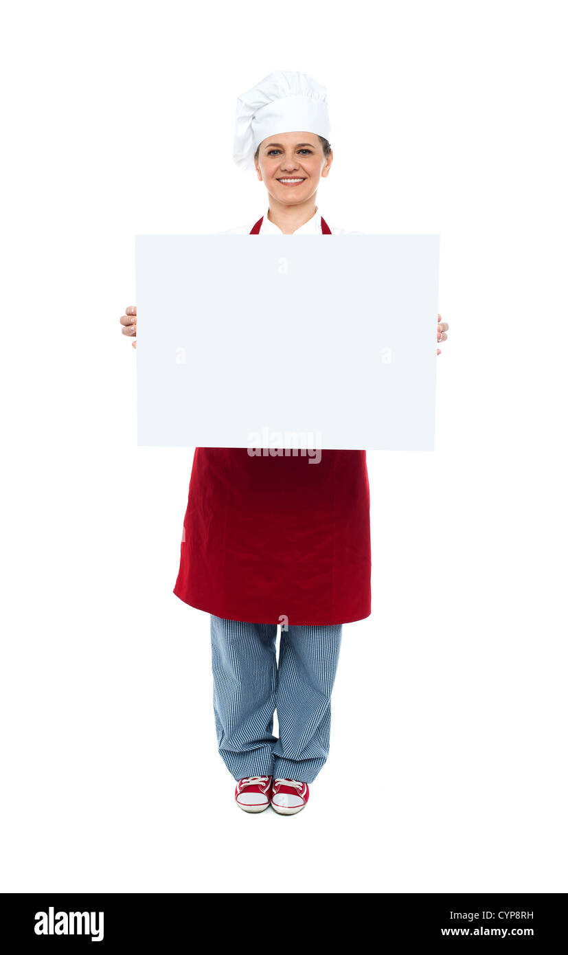 Lo chef sorridente visualizzazione bianco pubblicità board a piena lunghezza ritratto Foto Stock