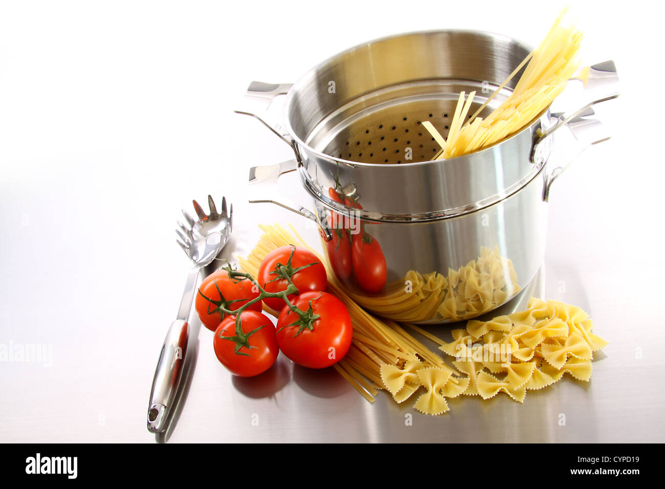 Vaso in acciaio inossidabile con pasta cruda e pomodori Foto Stock