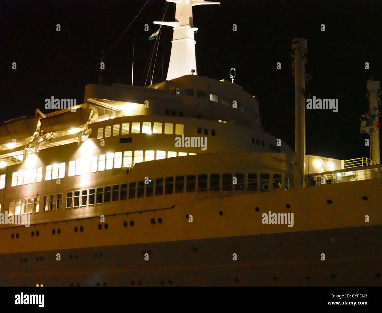 La SS Rotterdam, ex nave di linea passeggeri, è illuminata di notte mentre riposa nel suo porto. Questa iconica nave è un notevole esempio di design marittimo del dopoguerra e da allora è stata trasformata in hotel e museo. Foto Stock