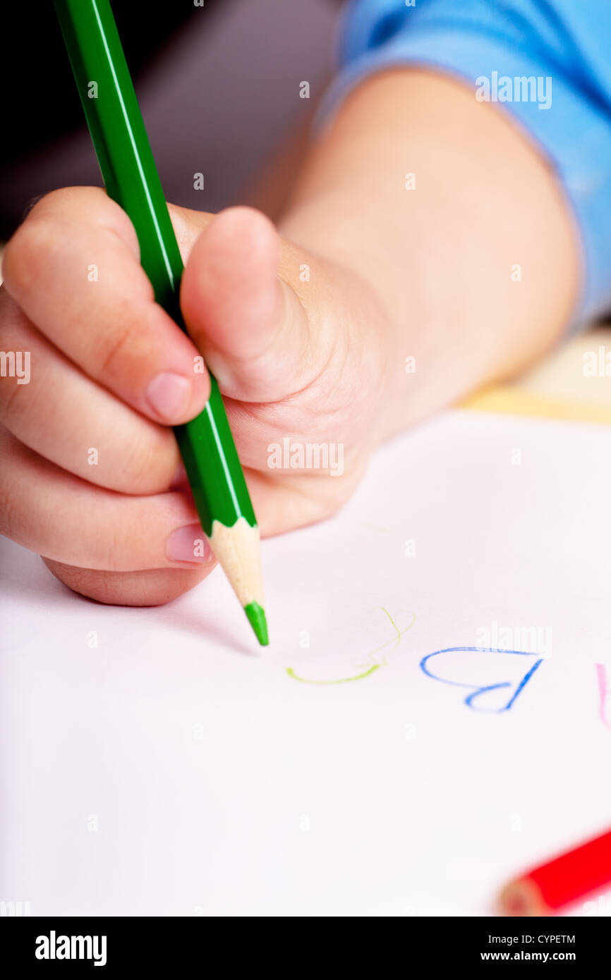 Bambino la mano per la scrittura di lettere con penna verde Foto Stock