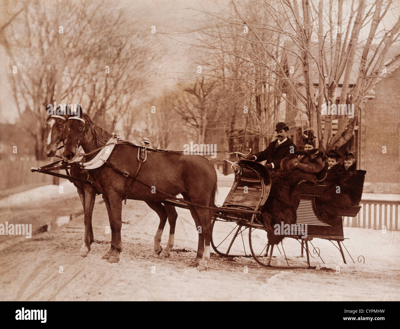 Famiglia seduto su una slitta trainata da cavalli, 1900 Foto Stock