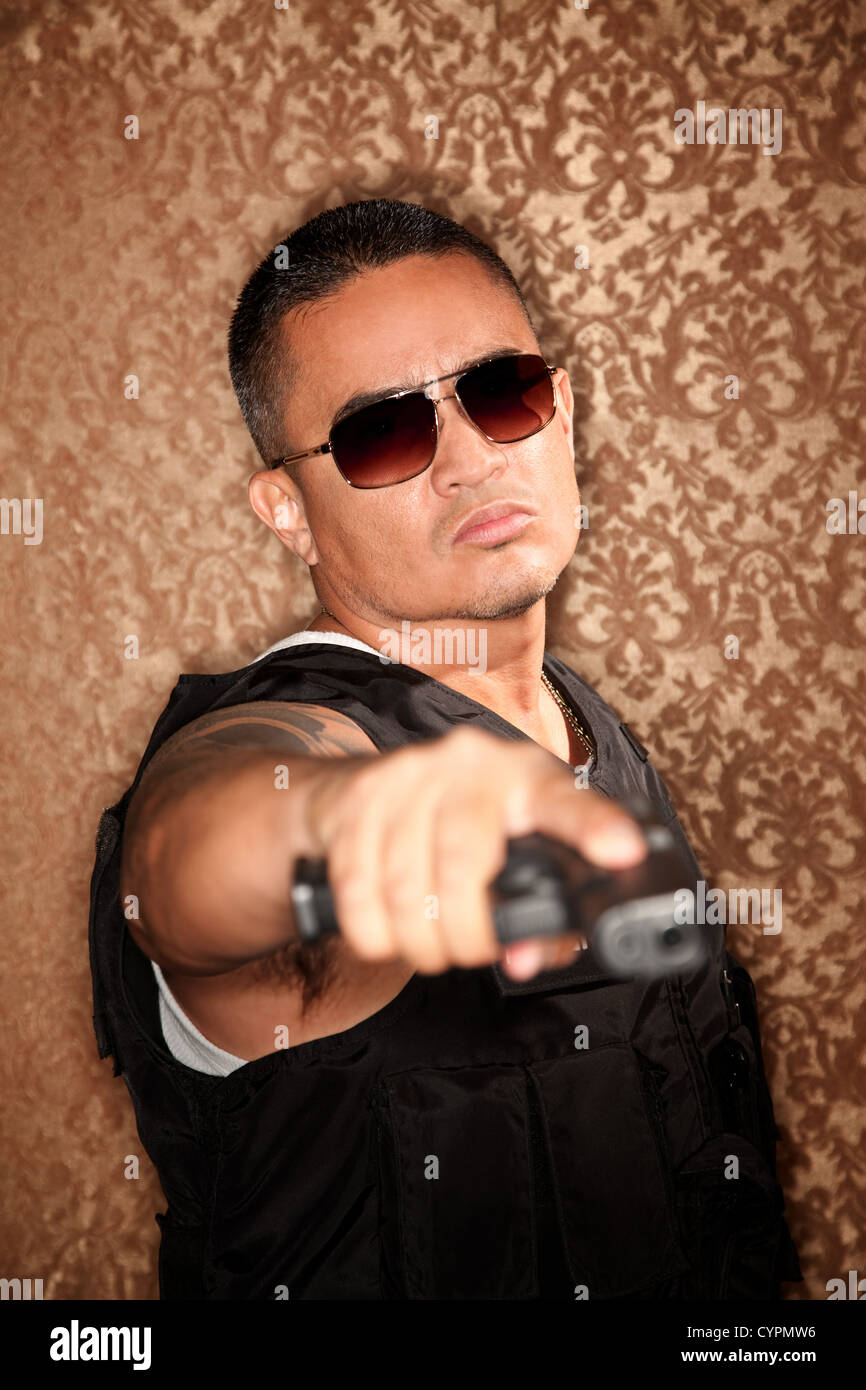 Cop ispanica pistola di puntamento a telecamera stile Gangster Foto Stock