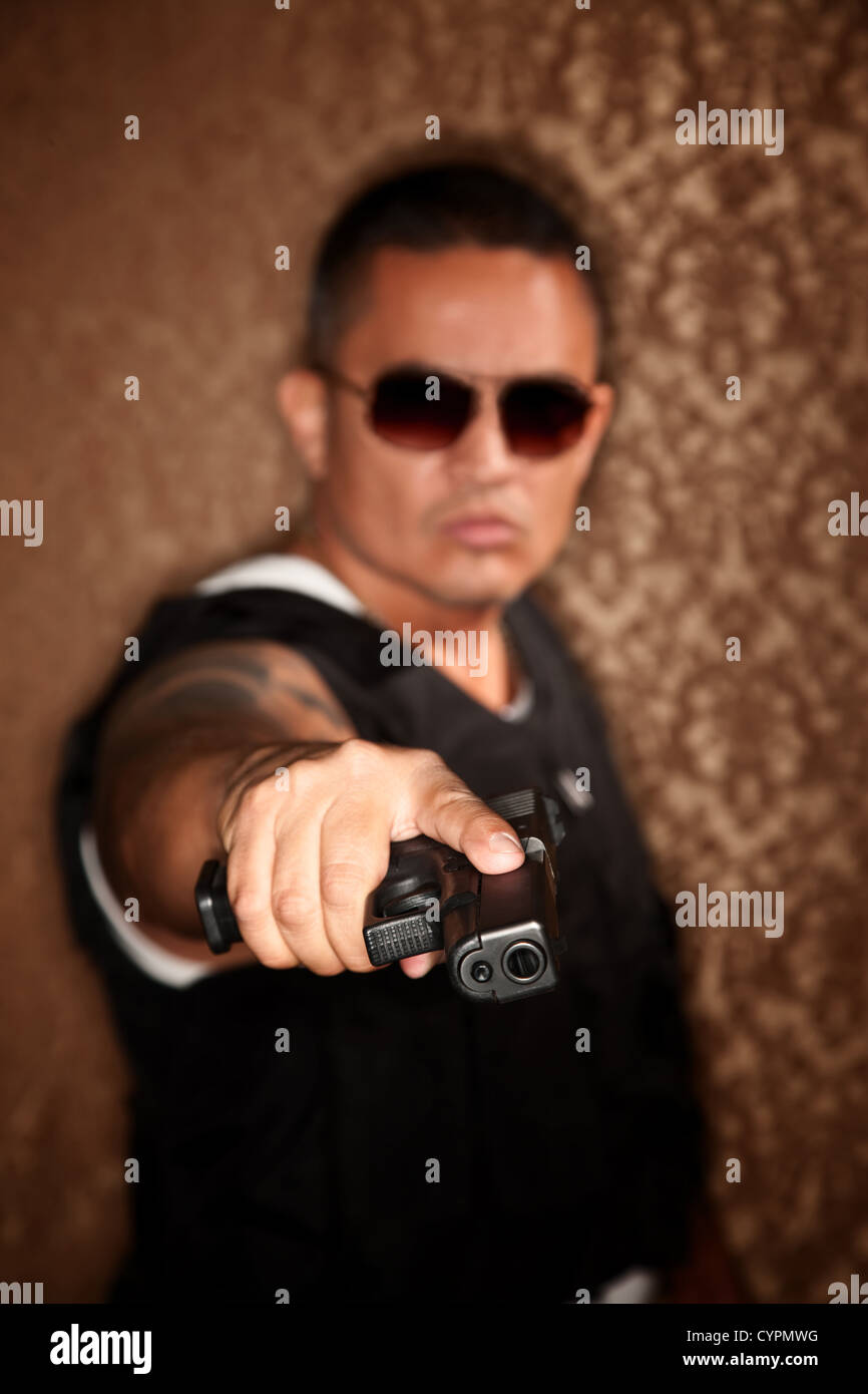 Cop ispanica pistola di puntamento a telecamera stile Gangster Foto Stock