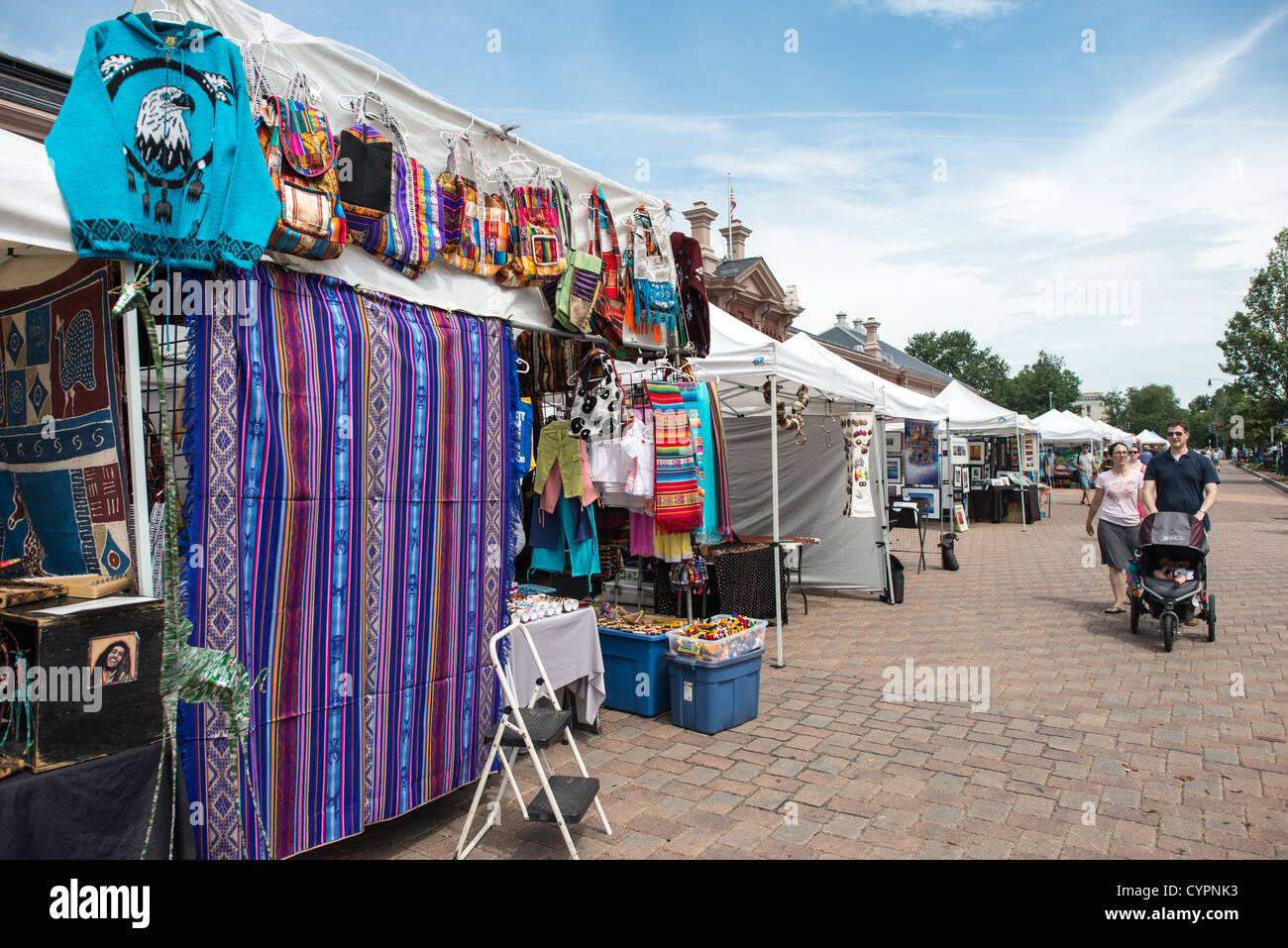 WASHINGTON DC, Stati Uniti — il trambusto vibrante del mercato orientale a Washington DC, un centro del commercio e della comunità locale. Essendo uno dei più antichi mercati pubblici del paese, il mercato orientale è rinomato per i suoi venditori di cibo fresco, gli artigiani locali e i commercianti di antiquariato, che incarnano il vivace carattere del quartiere di Capitol Hill. WASHINGTON DC, USA - Stand di abbigliamento e tessuti al mercato delle pulci Domenica a Eastern Market, un mercato storico su Capitol Hill a Washington DC. L'edificio originale del mercato fu gravemente danneggiato da un incendio nel 2007, e l'edificio ricostruito fu re Foto Stock