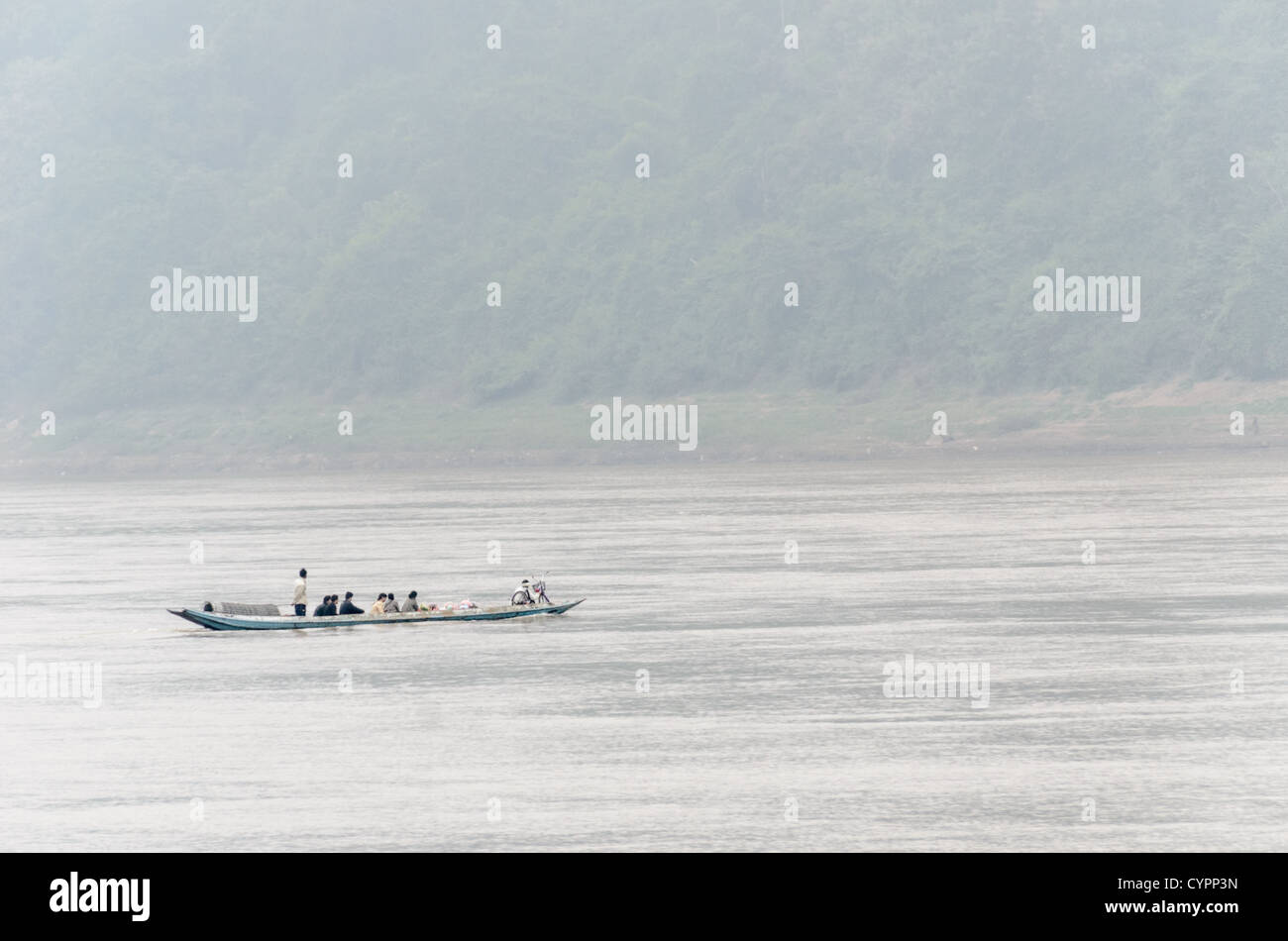 Fiume Mekong Sampan Boat Luang Prabang Laos // LUANG PRABANG, Laos — Un traghetto sampan attraversa il fiume Mekong vicino a Luang Prabang nel Laos centrale. La tradizionale barca in legno fornisce un trasporto essenziale attraverso il corso d'acqua in questa regione del paese. Luang Prabang, patrimonio dell'umanità dell'UNESCO dal 1995, si trova alla confluenza dei fiumi Mekong e Nam Khan nel Laos centro-settentrionale. L'antica capitale reale è conosciuta per la sua architettura ben conservata che combina influenze tradizionali del Laos e coloniali francesi. Il fiume Mekong scorre a circa 4.350 chilometri dal Tibeta Foto Stock