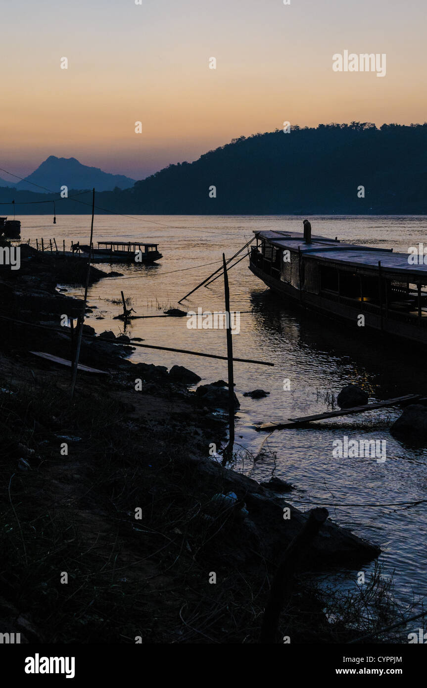 Fiume Mekong al tramonto Luang Prabang Laos // LUANG PRABANG, Laos - il fiume Mekong scorre vicino alla storica città di Luang Prabang nel Laos settentrionale al tramonto. Il Mekong, uno dei principali corsi d'acqua del sud-est asiatico, si estende per circa 4.350 chilometri dall'altopiano tibetano al Mar Cinese meridionale, sostenendo milioni di persone in sei paesi. Luang Prabang, patrimonio dell'umanità dell'UNESCO dal 1995, si trova alla confluenza dei fiumi Mekong e Nam Khan. L'antica capitale reale fu sede del regno di LAN Xang e rimane famosa per la sua ben conservata t buddista Foto Stock