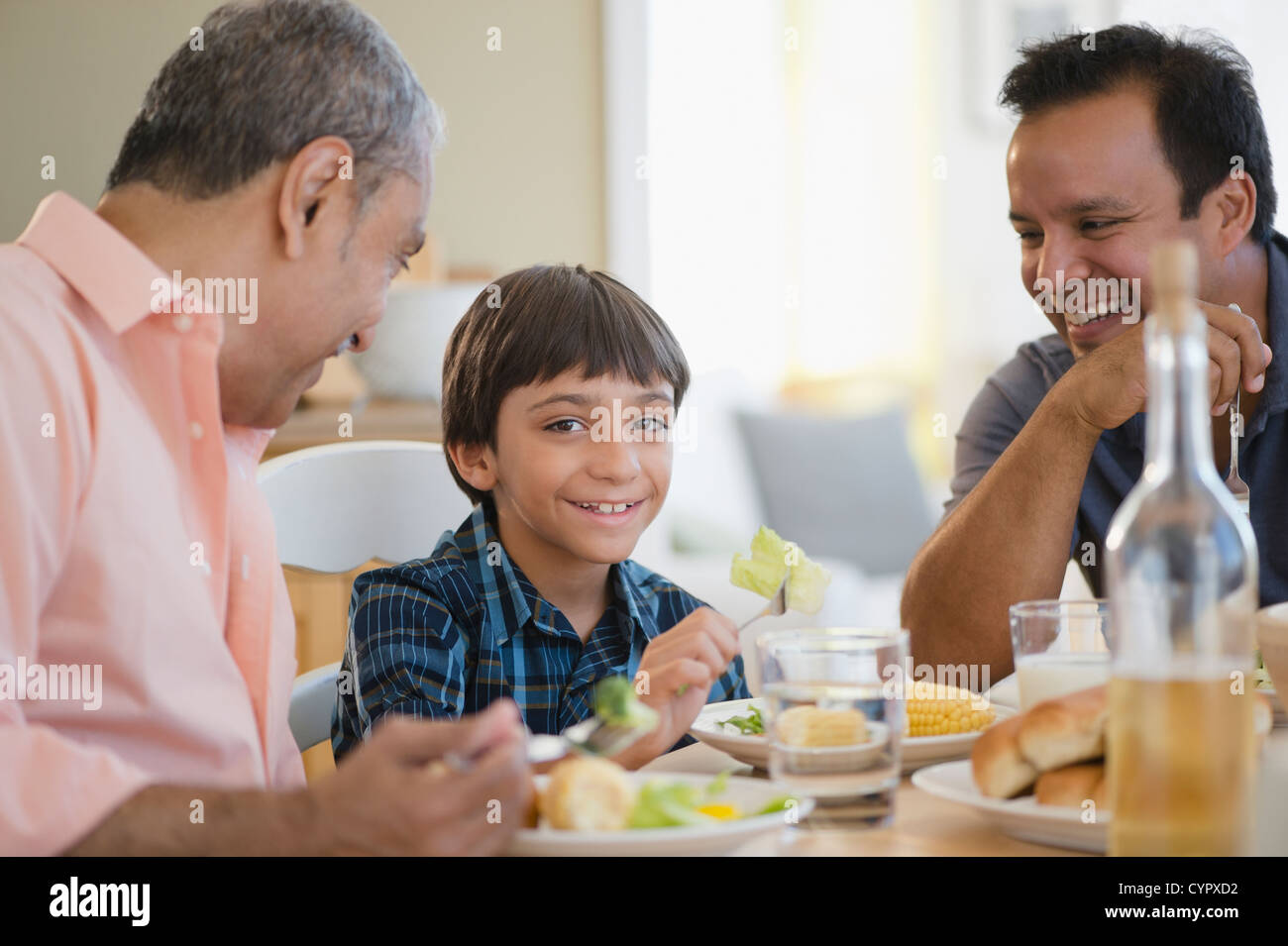 Nonno ispanica, padre e figlio di mangiare la cena Foto Stock